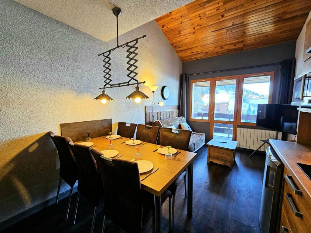 une salle à manger avec une table et un canapé dans l'établissement Résidence Le De 4 - Appartement 2 pièces pour 6 personnes de 35m² MAE-3881, à La Plagne Tarentaise
