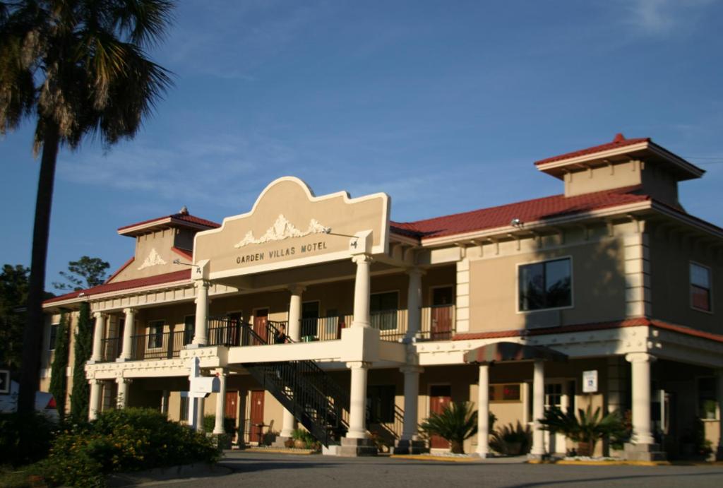 a large building with a sign for a hotel at The Garden Villas Hotel in Valdosta