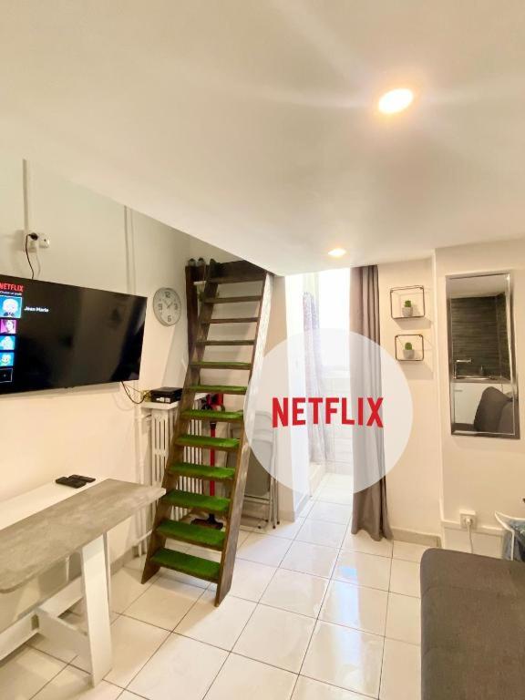 un salon avec un escalier en colimaçon et une télévision dans l'établissement Studio NYO Vieux Port, à Marseille