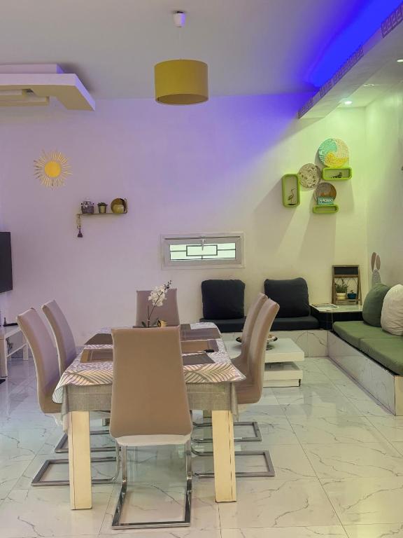 a dining room with a table and chairs and a couch at Grace house jacuzzi in Saly Portudal