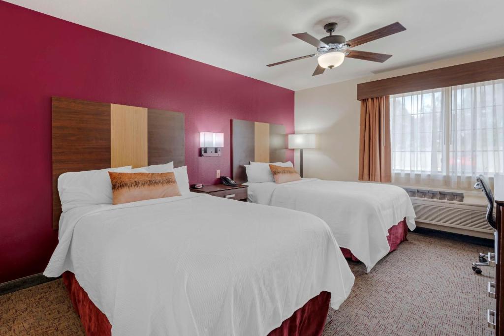 a hotel room with two beds and a ceiling fan at Best Western Pineywoods Inn in Atlanta