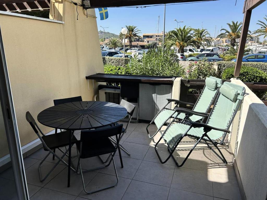 un patio avec une table et des chaises sur un balcon dans l'établissement Résidence Port Nature Colline 8 - Joli Studio T2 - 2 personnes Port Nature Colline 8 Rez de Chaussée MAE-5301, au Cap d'Agde