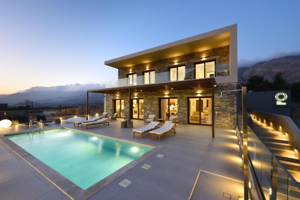 a house with a swimming pool at night at My Aloni Luxury Residences in Plakias