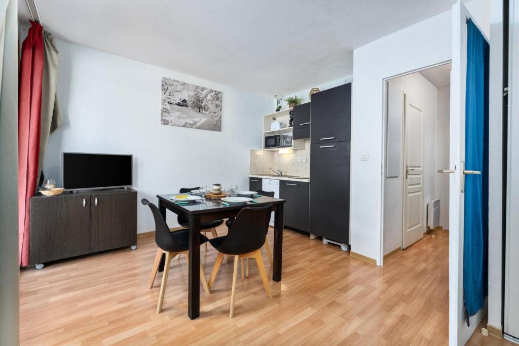 une cuisine et une salle à manger avec une table et des chaises dans l'établissement Résidence Les Terrasses Du Soleil D'or - Studio 4 personnes pour un séjour skis aux pieds MAE-7631, aux Orres