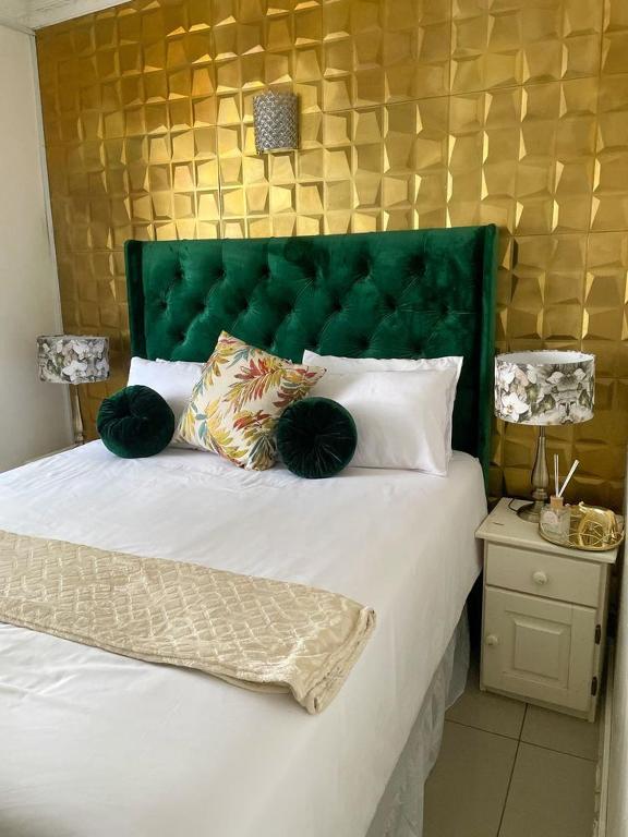 a bedroom with a large bed with a green headboard at Rachida Villa At Safari in Rundu