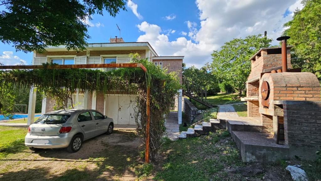 un coche aparcado delante de una casa en Casa planta alta 2 dormitorios, en Valle Hermoso