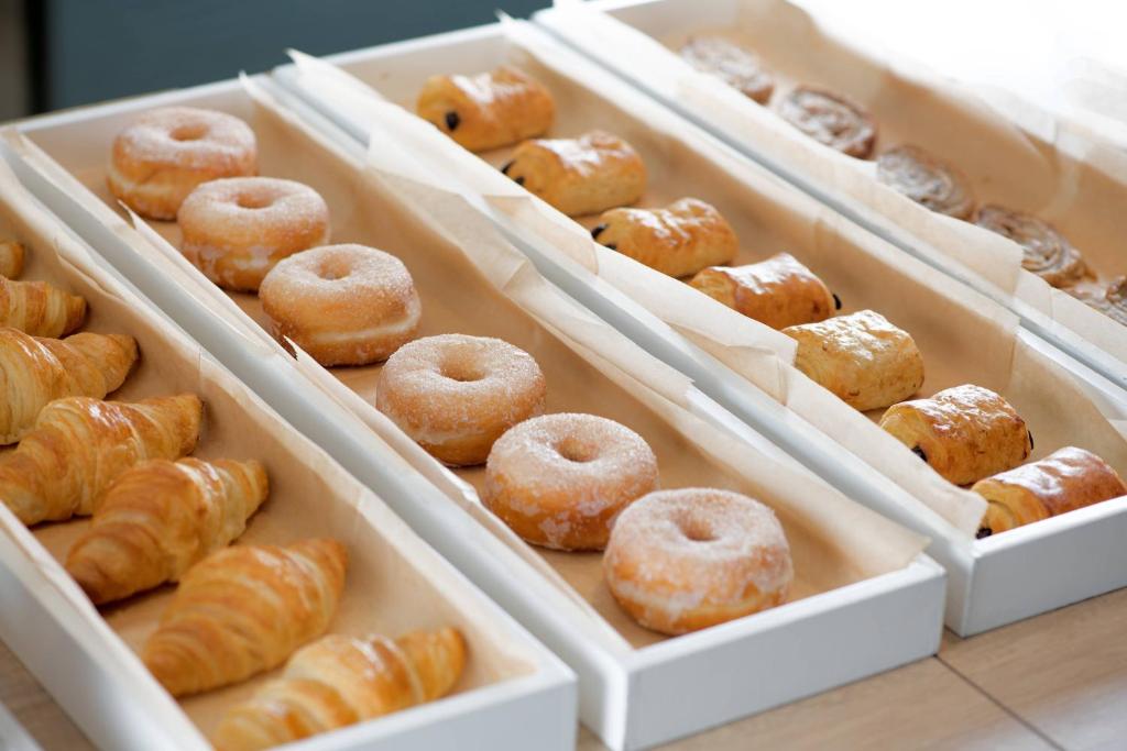 a bunch of donuts in white trays in a bakery at AC Hotel by Marriott Tenerife in Santa Cruz de Tenerife