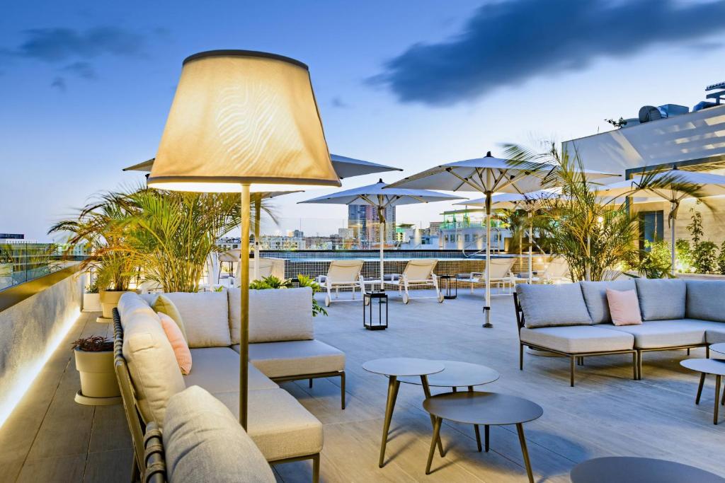 a patio with couches and tables on a roof at AC Hotel by Marriott Tenerife in Santa Cruz de Tenerife