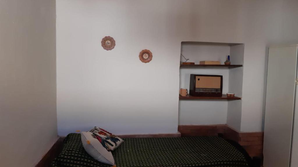a corner of a room with a bed and a mirror at La Casa de Amalia in Tumbaya