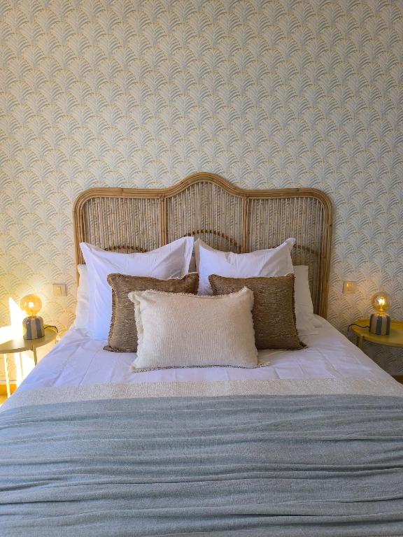 a bedroom with a bed with white sheets and pillows at Meloneras Garden Bungalow in Meloneras