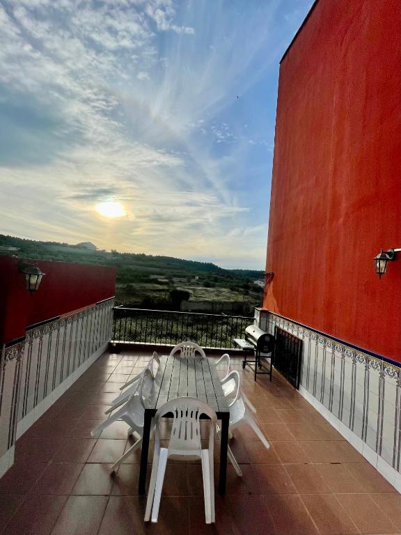 a patio with a table and chairs on a balcony at Casa Rural Piker in Bolbaite