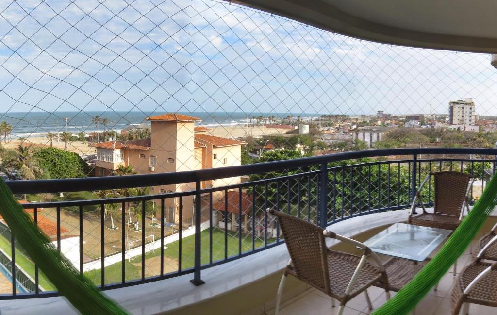 Un balcón con sillas y vistas al océano. en Beach Village Residence, en Fortaleza