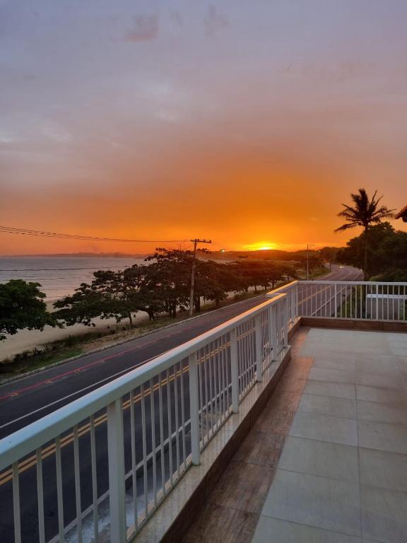 a sunset from the balcony of a condo at Jacarandá de Minas Vista Mar Praia de Meaipe Guarapari in Guarapari
