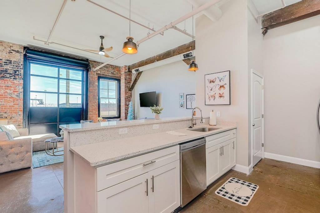 a kitchen with a sink and a living room at Breakfast at Tiffanys Downtown Newport News in Hampton
