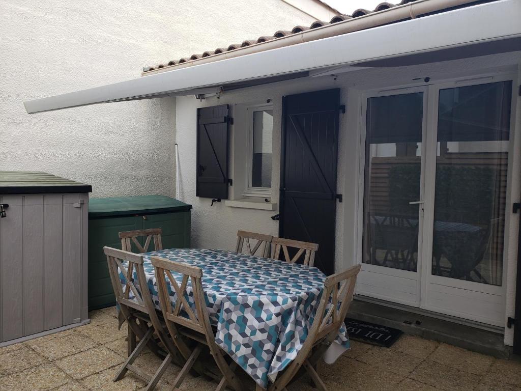 une table et des chaises assises sur une terrasse dans l'établissement Capbreton - Villa Patio - Climatisé - Port - Surf, à Capbreton