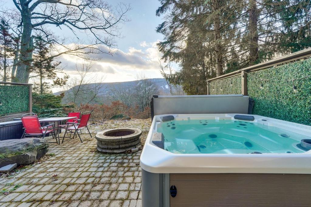 タナーズビルにあるMtn-View Gem with Deck and Hot Tub in Tannersvilleのホットタブ付きのパティオ(テーブル、椅子付)