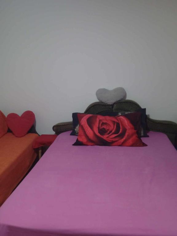 a bed with a red rose pillow on it at Nea Iskra Vyletska Berezhanska street in Lviv