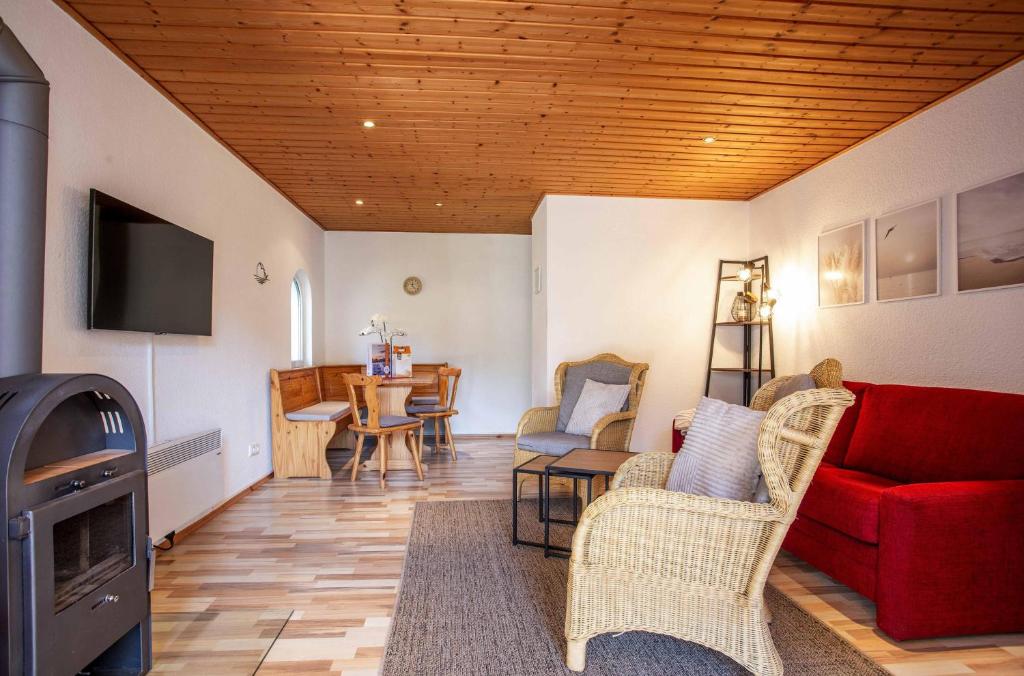 a living room with a red couch and a table at Ferienhaus MöwenNest mit Garten und Kamin in Silz