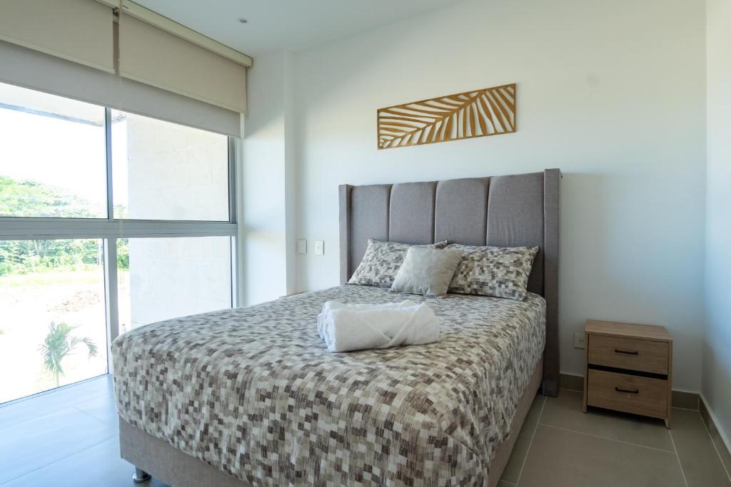 a bedroom with a large bed and a large window at BAIA Kristal Cartagena Condo in Cartagena de Indias
