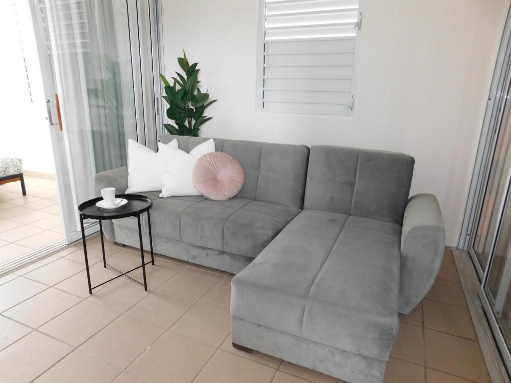 a living room with a gray couch and a table at Apartment Close to Beach & Private Parking in San Juan