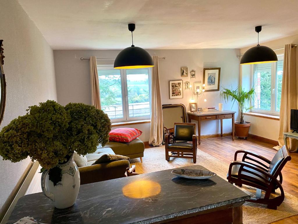 un salon avec un vase de fleurs sur une table dans l'établissement Gîte écologique familial en campagne, idéal pour sports et nature - FR-1-410-452, à Moulins-le-Carbonnel