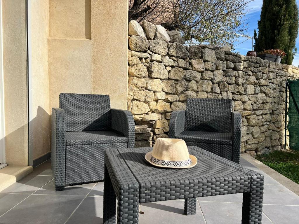 Deux chaises et une table avec un chapeau dans l'établissement Maison sur la colline du Barroux, à Le Barroux