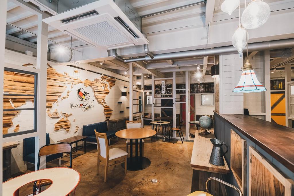高松市にあるKotori Coworking &amp; Hostel Takamatsuのテーブルと椅子とバーのあるレストラン