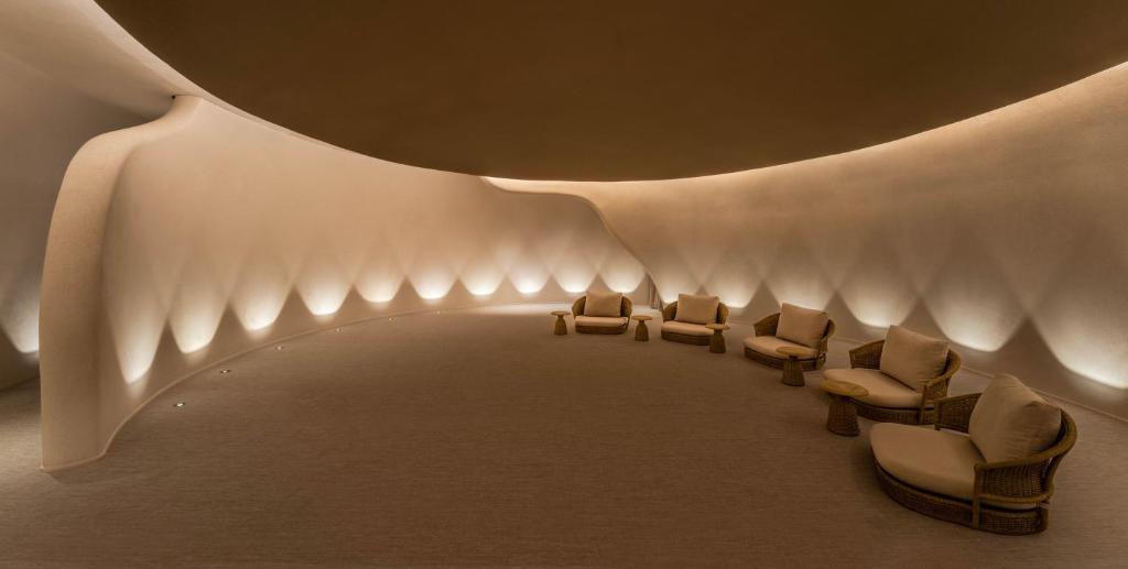 a lobby with chairs and a ceiling with lights at Dusit Thani Bangkok in Bangkok