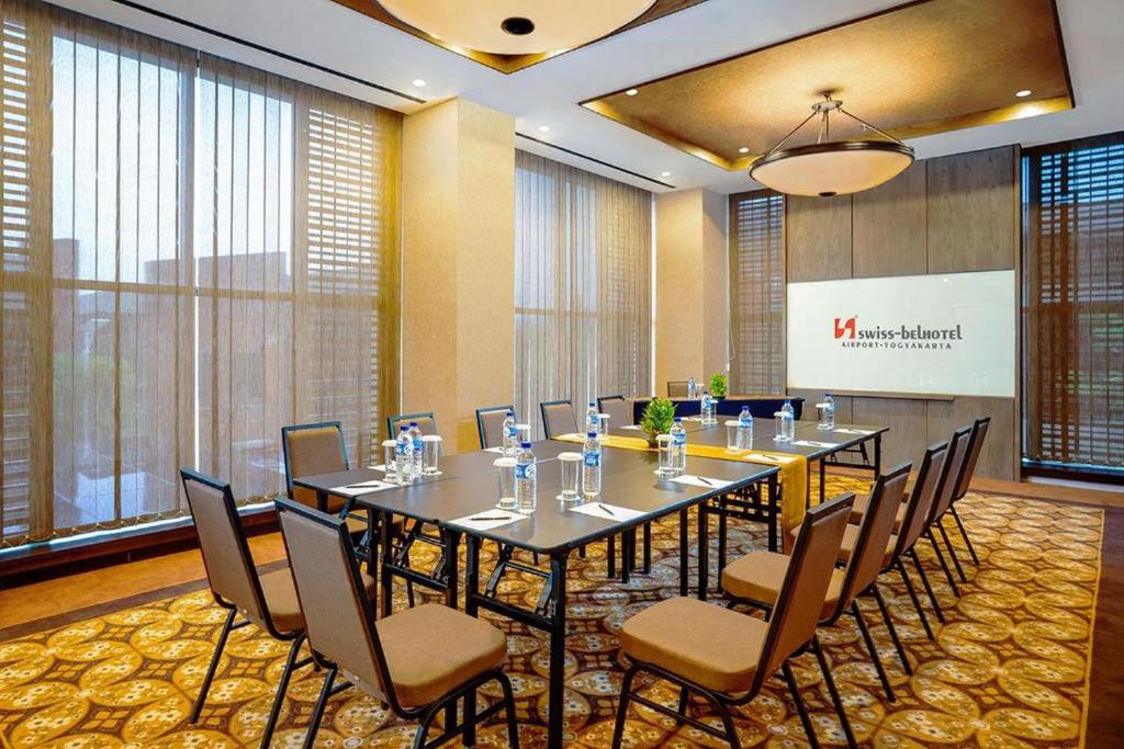 a conference room with a large table and chairs at Swiss-Belhotel Airport Yogyakarta in Yogyakarta