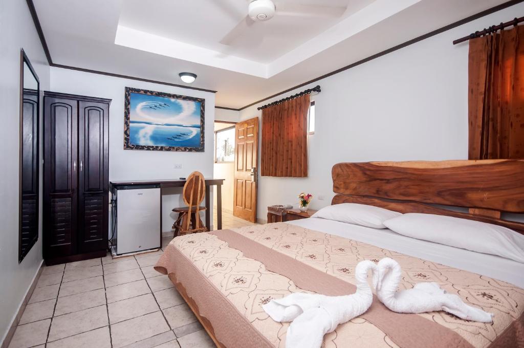 1 dormitorio con 1 cama con 2 toallas en Cadillac Rock Beach Hotel, en Jacó