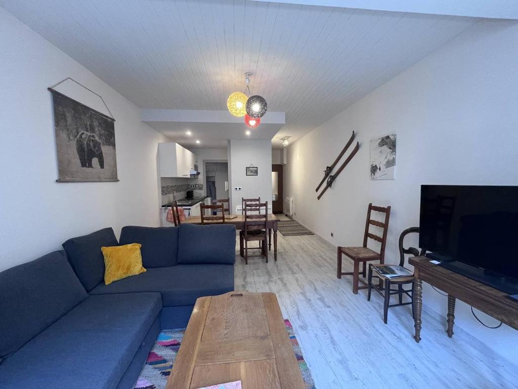 un salon avec un canapé bleu et une table dans l'établissement Appartement duplex à Cauterets avec sauna privé et wifi - FR-1-812-87, à Cauterets