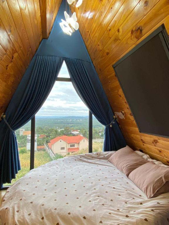 Buôn Dhă PrŏngにあるKakul A'Houseの大きな窓のある部屋のベッド