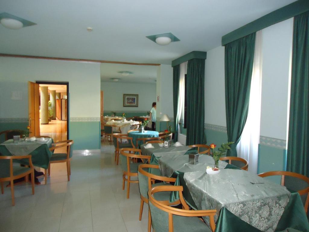 jadalnia ze stołami i krzesłami w restauracji w obiekcie Hotel D.G. Garden w mieście Benewent