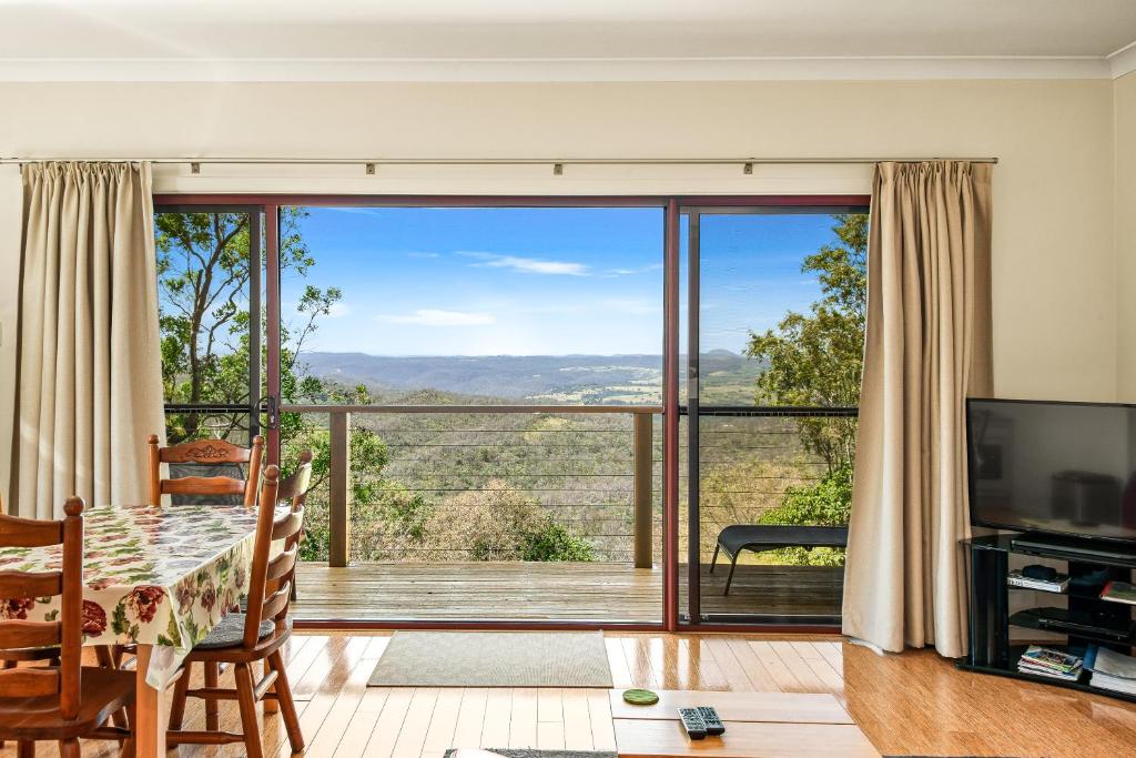 a living room with a table and a large window at ecoRidge Hideaway in Preston