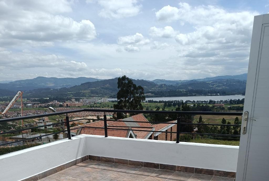 a balcony with a view of a river and mountains at Villa Graciela II in Paipa