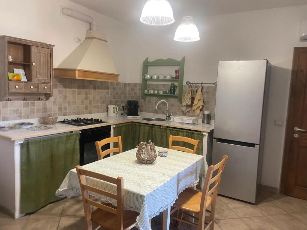 eine Küche mit einem Tisch mit Stühlen und einem Kühlschrank in der Unterkunft Charming House in Vittoria in Vittoria
