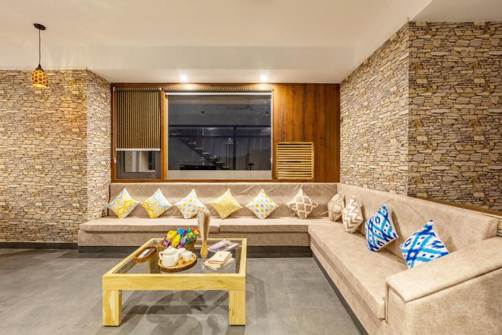 un soggiorno con un divano e un tavolo di Alaya Stays 4 BHK with Pvt Plunge pool - Lumbini a Udaipur