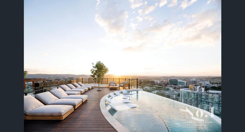 布里斯班Luxury Peppers Infinity Pool Stylish with 2BD & 1C Park的带沙发的阳台和建筑物上的游泳池