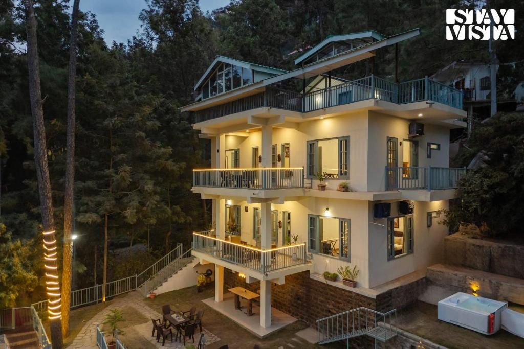 Blick auf ein Haus in der Nacht in der Unterkunft StayVista at Pinecrest Manor - Outdoor Jacuzzi in Kasauli