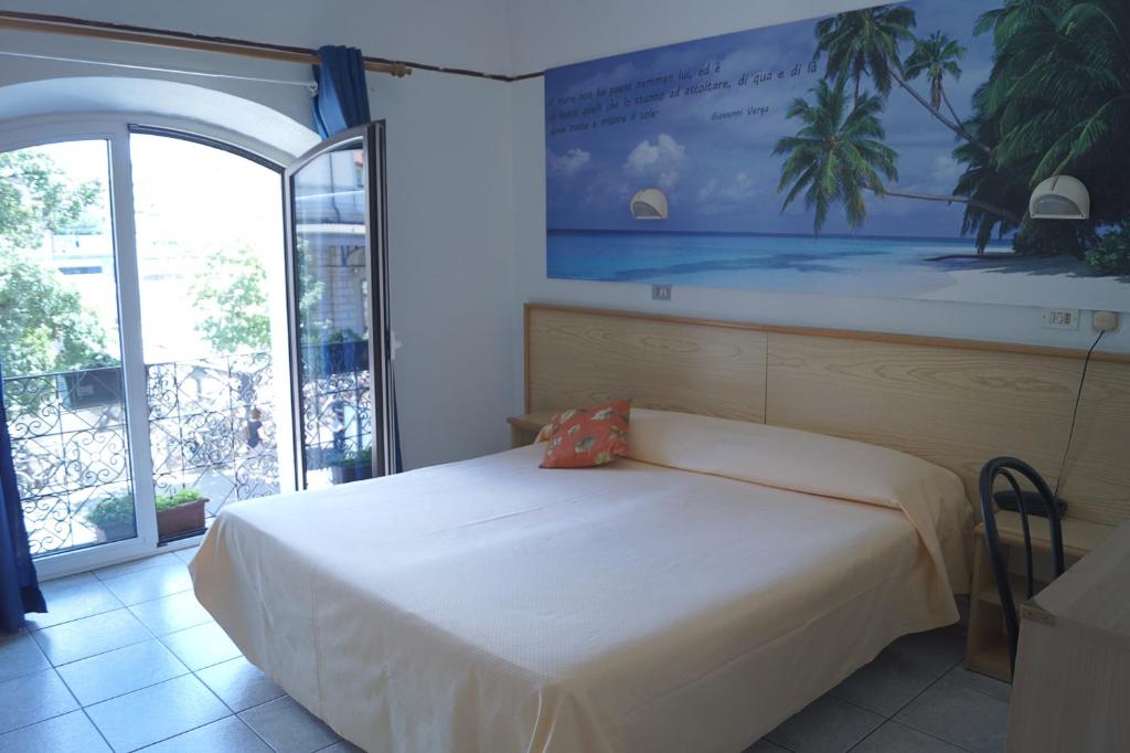 a bedroom with a bed and a large window at Hotel Stazione in Novara