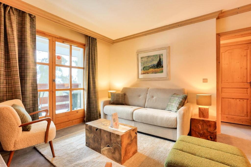 un salon avec un canapé et une table dans l'établissement Résidence Les Arcs 1950 Le Village - maeva Home - Appartement 3 pièces 6 personnes - Prestige MAE-5091, à Bourg-Saint-Maurice