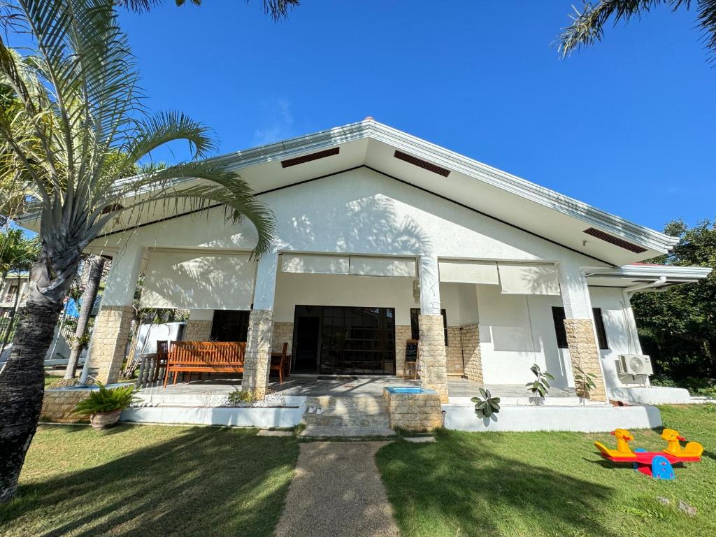 una casa blanca con una palmera en el patio en Sea Start Villa, en Panglao