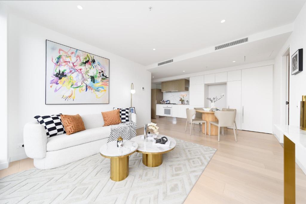 ein weißes Wohnzimmer mit einer Couch und einem Tisch in der Unterkunft Top CBD Skyline Luxury Apartments 2 Beds or 3 Beds, 2 Baths, Free Parking in Melbourne
