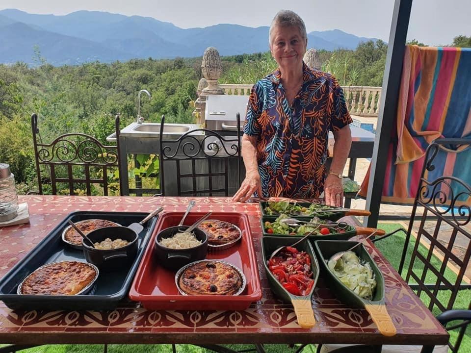 une femme debout devant une table de nourriture dans l'établissement Villa la Cerisaie., à Céret