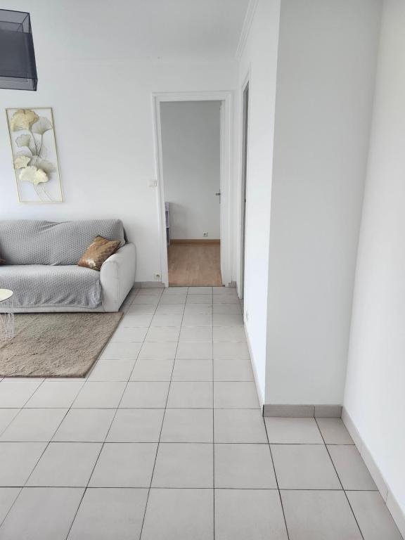 - un salon avec un canapé et du carrelage dans l'établissement Joli F3 Montpellier proche mer et centre ville, à Montpellier