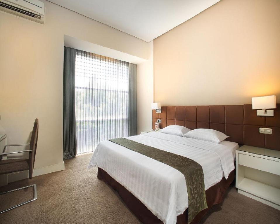 Postel nebo postele na pokoji v ubytování Grand Kecubung Hotel
