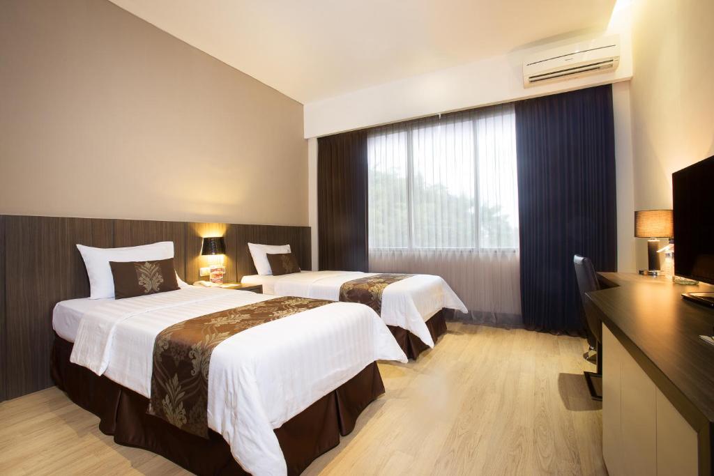 Postel nebo postele na pokoji v ubytování Grand Kecubung Hotel