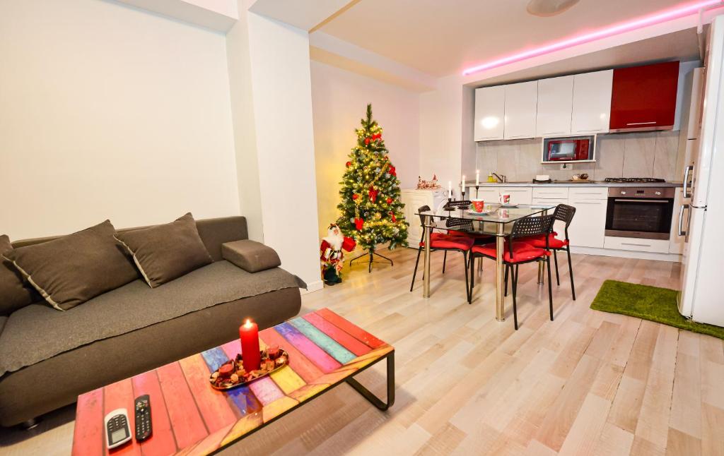 ein Wohnzimmer mit einer Couch und einem Weihnachtsbaum in der Unterkunft Adam and Eve Luxury Apartments - Shabbat Friendly in Bukarest