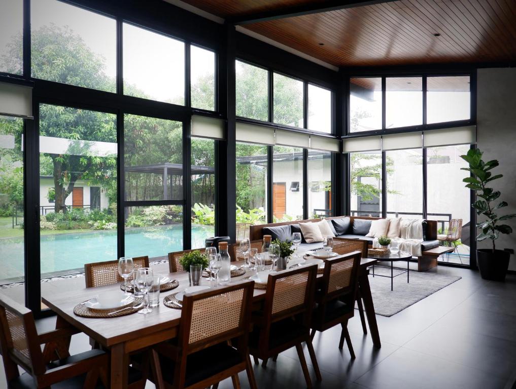 Un comedor con una mesa larga con sillas y un sofá. en Querencia Villa, en Ángeles