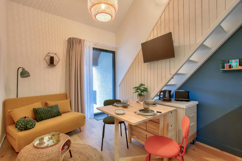 a small living room with a table and a couch at 250m de la plage - Charmant studio in La Richardais